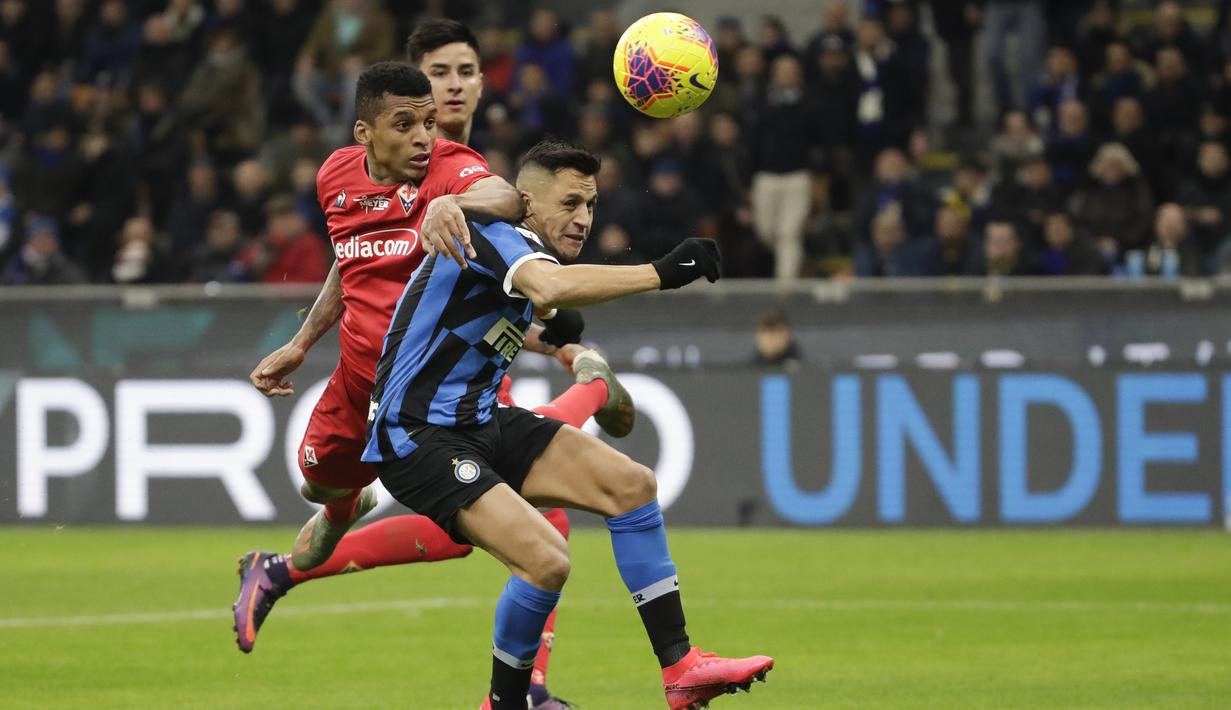 Striker Inter Milan, Alexis Sanchez, berebut bola dengan pemain Fiorentina, Dalbert, pada laga Coppa Italia di Stadion San Siro, Rabu (29/1/2020). Inter Milan menang 2-1 atas Fiorentina. (AP/Luca Bruno)