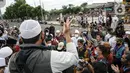 Massa pendukung Rizieq Shihab memintas rekannya membubarkan diri di flyover Penggilingan, Jakarta, Kamis (24/6/2021). Sebelumnya, polisi dengan para simpatisan Rizieq Shihab terlibat bentrokan jelang sidang vonis perkara tes swab yang digelar di di PN Jakarta Timur. (Liputan6.com/Faizal Fanani)