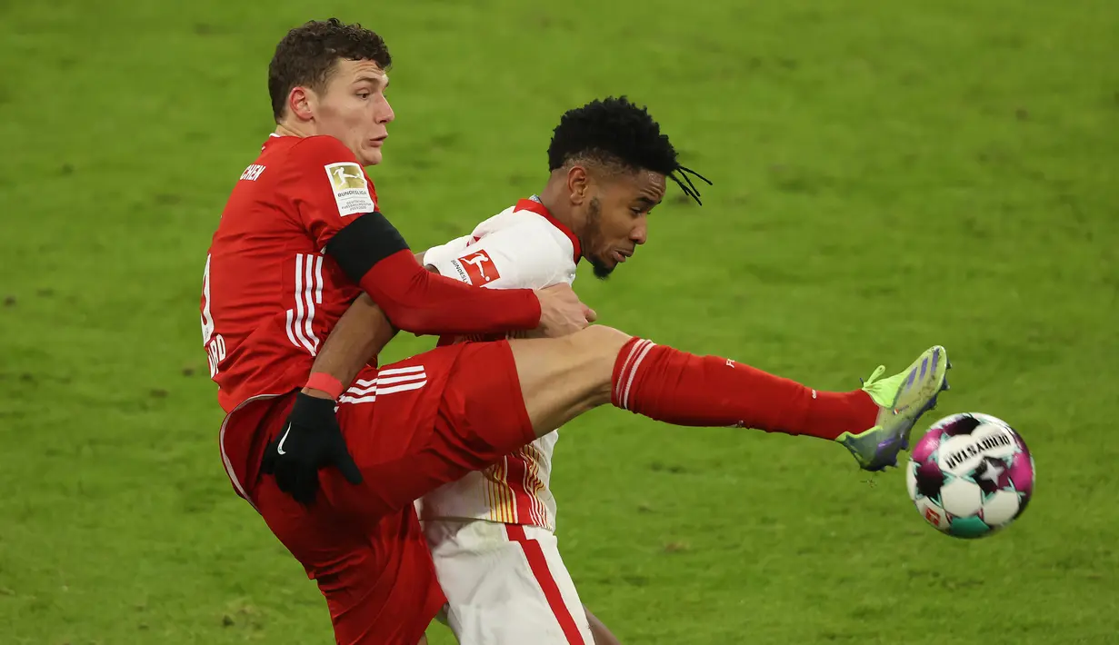 Bek Bayern Munich, Benjamin Pavard (kiri), berebut bola dengan gelandang RB Leipzig, Christopher Nkunku, dalam laga lanjutan Liga Jerman pekan ke-10 di Allianz Arena, Sabtu (5/12/2020). Bayern Munich bermain imbang 3-3 dengan RB Leipzig. (AFP/Alexander Hassenstein/Pool)