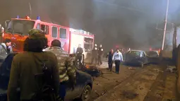 Mobil pemadam kebakaran di kerahkan ke lokasi ledakan truk tangki pengangkut BBM di sebuah pasar di kota Azaz, perbatasan Suriah dan Turki, Sabtu (7/1). Sebagian besar korban adalah warga sipil yang tewas ketika tangki meledak. (STRINGER/AFPTV/AFP)