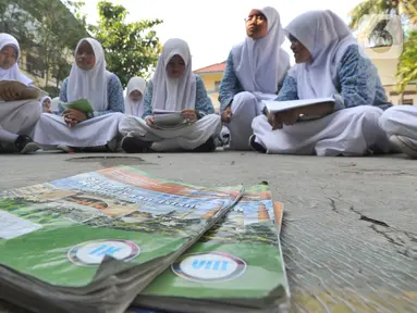 Siswa kelas VIII belajar mata pelajaran Sejarah Kebudayaan di halaman sekolah Mts. Hidayatul Umam di Cinere, Depok, Kamis (7/11/2019). Kegiatan hari belajar di luar kelas yang serentak di seluruh Indonesia ini dilakukan dalam rangka memperingati hari anak internasional. (merdeka.com/Arie Basuki)