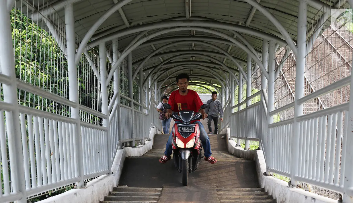 Pengendara sepeda motor melewati Jembatan Penyeberangan Orang (JPO) di kawasan Pasar Minggu, Jakarta, Selasa (17/10). JPO yang diperuntukkan bagi pejalan kaki itu sering dimanfaatkan pengendara motor sebagai jalan pintas. (Liputan6.com/Immanuel Antonius)