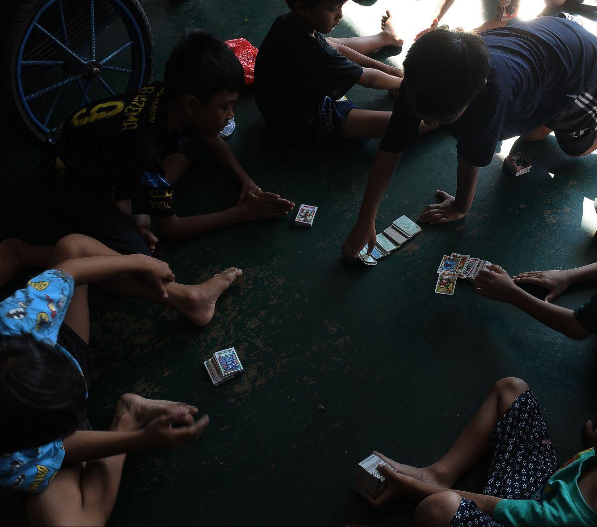 Sejumlah anak bermain kartu kuartet atau kartu gambar di kawasan Pasar Jatinegara, Jakarta, Sabtu (20/4/2024). Siapa yang tak kenal dengan permainan kartu kuartet atau kartu gambar? Permainan jadul ini sudah menemani masa kanak-kanak bagi banyak orang, te