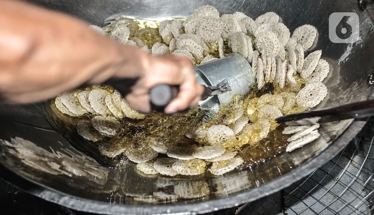 Pekerja menggoreng kerupuk saat produksi rutin di industri rumahan kawasan Cipinang Melayu, Jakarta, Selasa (16/2/2021). Pemilik industri kerupuk rumahan ini berharap Covid-19 segera berakhir agar industri kerupuk yang dirintis turun-temurun itu dapat normal kembali. (merdeka.com/Iqbal S Nugroho)