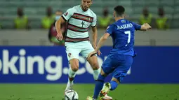 Bek Portugal, Ruben Dias mengontrol bola dari kawalan pemain Azerbaija, Namik Alaskarov pada pertandingan kualifikasi grup A Piala Dunia 2022 di stadion Olimpiade di Baku, Azerbaijan, Selasa (7/9/2021). Portugal menang telak atas Azerbaijan 3-0. (AFP/Tofik Babayev)
