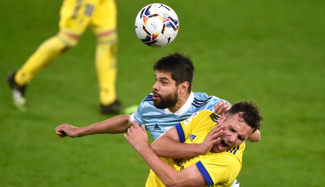 Bek Celta Vigo, Nestor Araujo, berebut bola dengan penyerang Cadiz, Alvaro Gimenez, pada laga lanjutan Liga Spanyol di Stadion Abanca Balaidos, Selasa (15/12/2020) dini hari WIB. Celta Vigo menang telak 4-0 atas Cadiz. (AFP/Miguel Riopa)