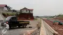 Pekerja mengganti ban di samping Musala yang masih berdiri di lokasi pembangunan proyek Tol Cinere-Jagorawi (Cijago) seksi II di Depok, Jawa Barat, Selasa (1/11). (Liputan6.com/Johan Tallo)