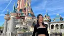 Saat mengunjungi Disneyland, ia tampil dengan rok mini dan strapless cropped top warna hitam. (Foto: Instagram @karbearv)