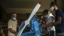 Adolfo Rivera melepas plastik pelindung pesawat kayu yang dia buat di garasi gedung apartemennya di Havana, Kuba, 19 Februari 2021. Selama hampir setahun, Rivera telah memiliki semua prosedur yang berlaku untuk terbang, meskipun pandemi COVID-19 menunda rencana mereka. (AP Photo/Ramon Espinosa)