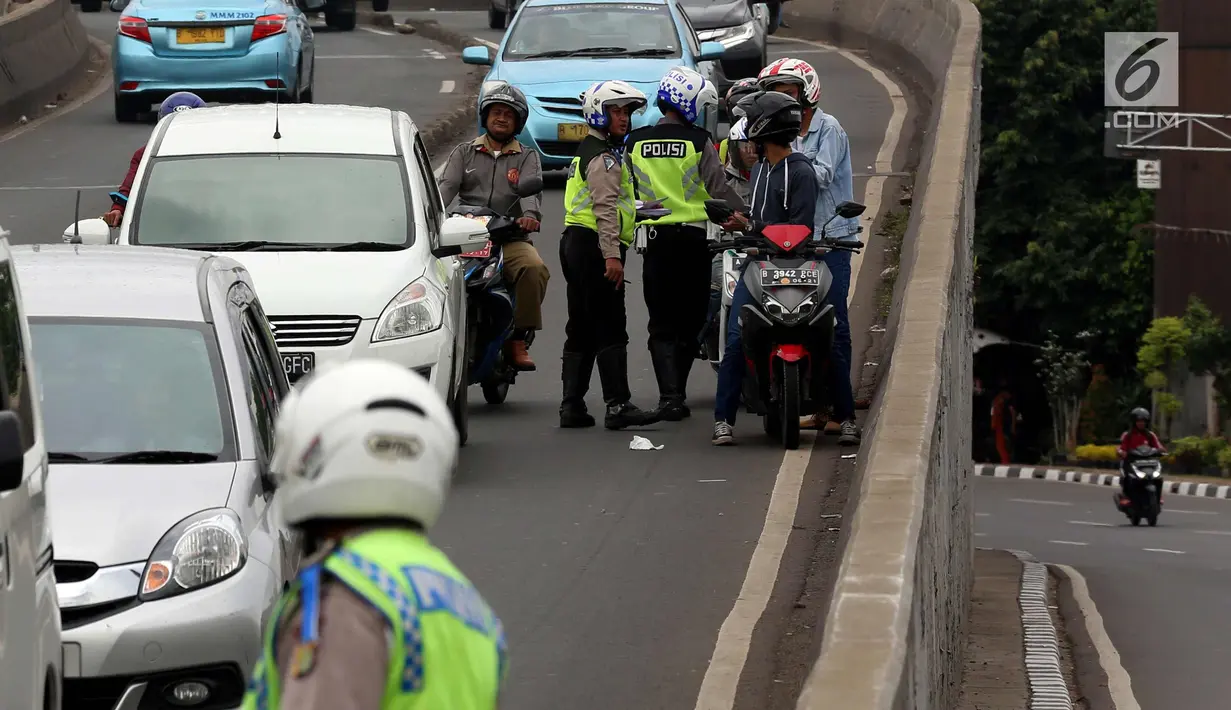 Petugas kepolisian memeriksa kelengkapan surat pengendara motor saat Operasi Zebra Jaya 2017 di Daan Mogot, Jakarta, Selasa (7/11). Operasi Zebra yang digelar 1 November- 14 Desember 2017. (Liputan6.com/Johan Tallo)
