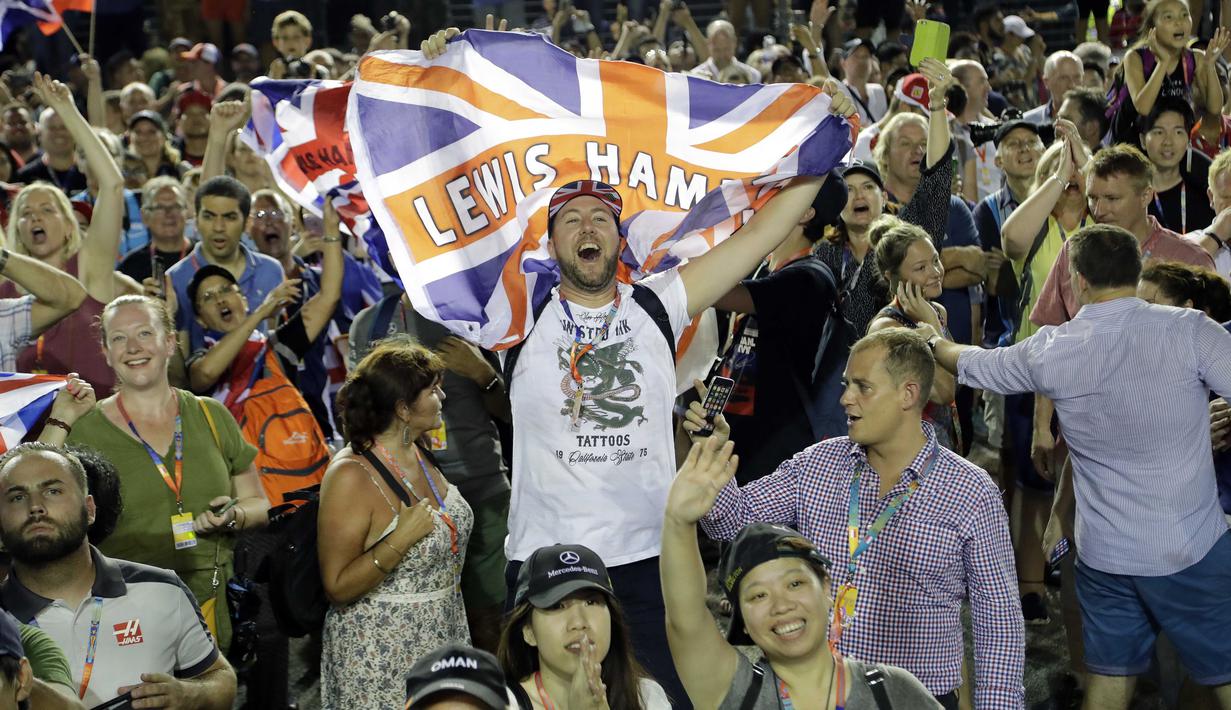 Seorang Fans membawa bendera Inggris saat mendukung Lewis Hamilton pada balapan F1 Singapura di Marina Bay City Circuit Singapore, (17/9/2017). (AP/Wong Maye-E)