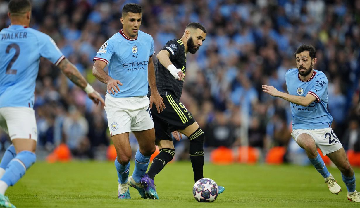 Pemain Manchester City, Bernardo Silva, berusaha merebut bola dari pemain Real Madrid, Karim Benzema, pada laga semifinal leg kedua di Stadion Etihad, Kamis (18/5/2023). Man City menang dengan skor 4-0. (AP Photo/Jon Super)