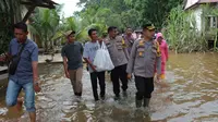 Kapolres Kampar AKBP Ronald Sumaja datang ke Desa Buluh Cina memberikan bantuan sembako dan berbincang dengan warga terkait situasi keamanan di desa. (Liputan6.com/ M Syukur)