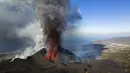 Lava mengalir dari gunung berapi di pulau Canary La Palma, Spanyol (30/11/2021). Beberapa lubang vulkanik baru dibuka di La Palma, melepaskan lava baru yang mengalir cepat menuruni punggung bukit dan akan memperluas dampak pada tanah yang dievakuasi , infrastruktur dan rumah. (AP/Emilio Morenatti)
