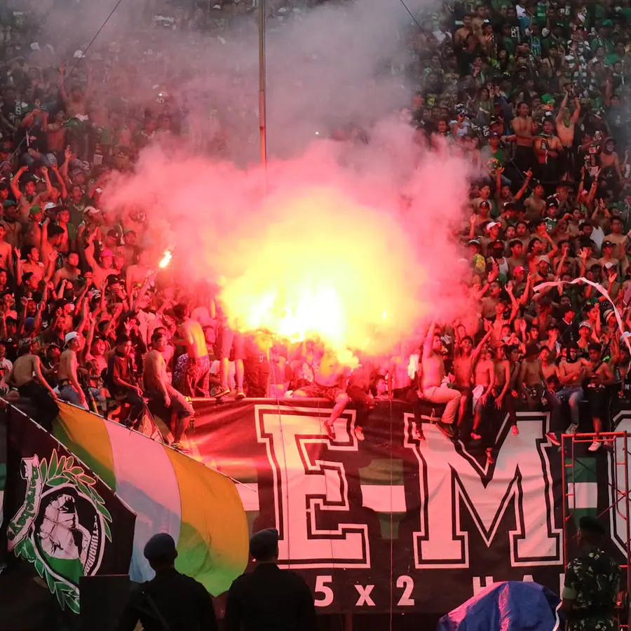 Bonek Mania menyalakan flare saat laga Persebaya vs Madura United di Stadion GBT, Surabaya (28/1/2018). (Bola.com/Aditya Wany)