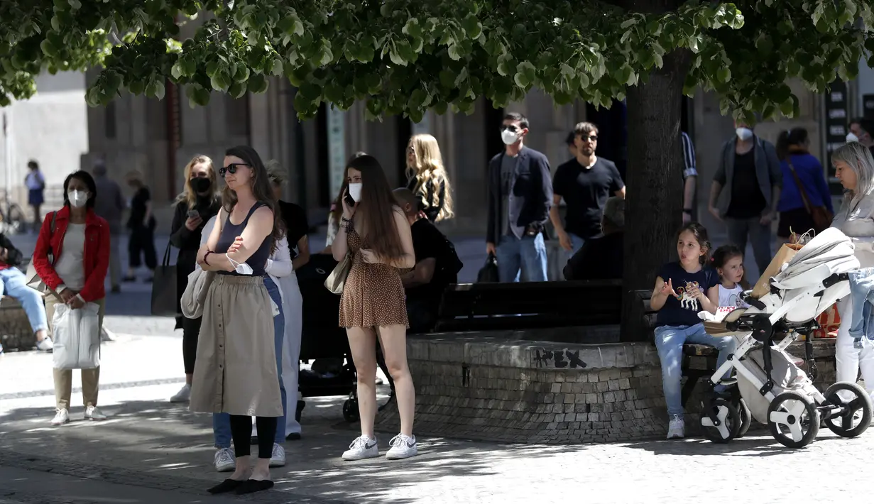 Orang-orang mengantre di depan sebuah toko di Praha, Republik Ceko, Senin (10/5/2021). Ceko secara besar-besaran melonggarkan pembatasan corona COVID-19 karena negara paling terpukul pandemi di Eropa itu memberikan penghormatan kepada hampir 30.000 korban meninggal. (AP Photo/Petr David Josek)