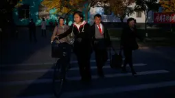 Orang-orang menyeberang jalan saat sore hari di Pyongyang, Korea Utara, (20/10). (AP Photo / Dita Alangkara)
