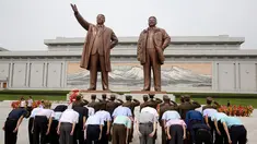 Tentara memberi hormat ketika yang lain membungkuk di hadapan patung pemimpin Korea Utara Kim Il Sung dan Kim Jong Il dalam peringatan berakhirnya Perang Dunia II dan pembebasan dari kolonial Jepang di Pyongyang, Korut, Rabu (15/8). (AP Photo/Ng Han Guan)