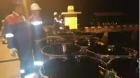 Petugas tengah menyedot limbah minyak hitam di perairan Tanjungpinang (Foto: Batamnews)
