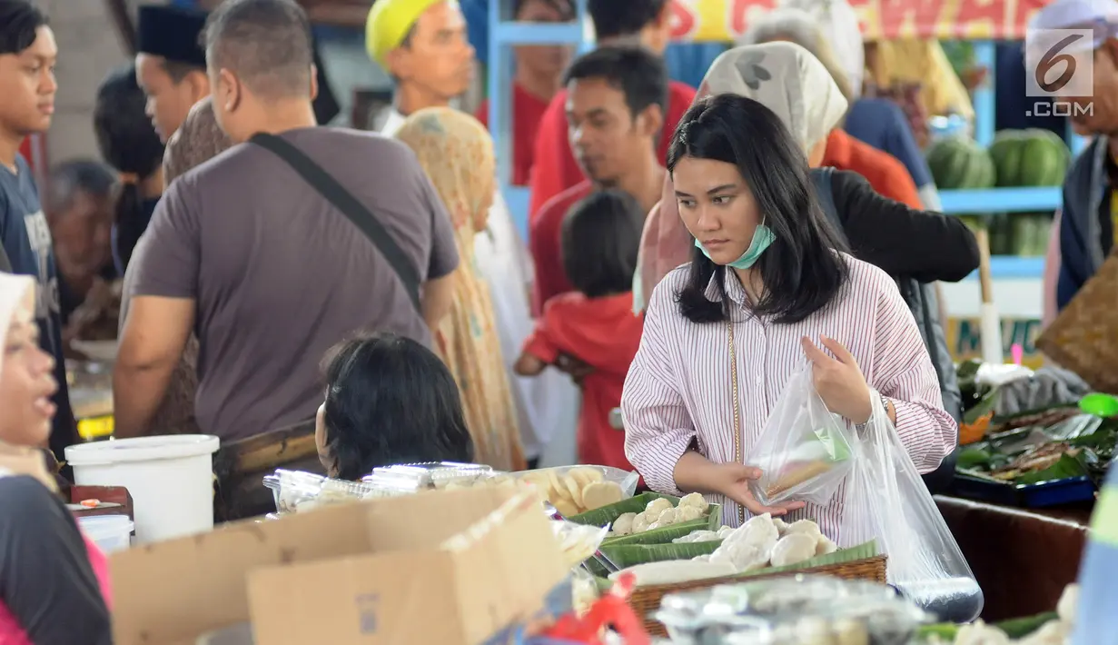 Warga memilih makanan dan minumam untuk berbuka puasa atau takjil di kawasan Bendungan Hilir atau Benhil, Jakarta, Senin (6/5/2019). Kawasan Benhil menjadi tempat warga dan pekerja kantoran untuk berburu menu takjil setiap Ramadan. (Liputan6.com/Herman Zakharia)