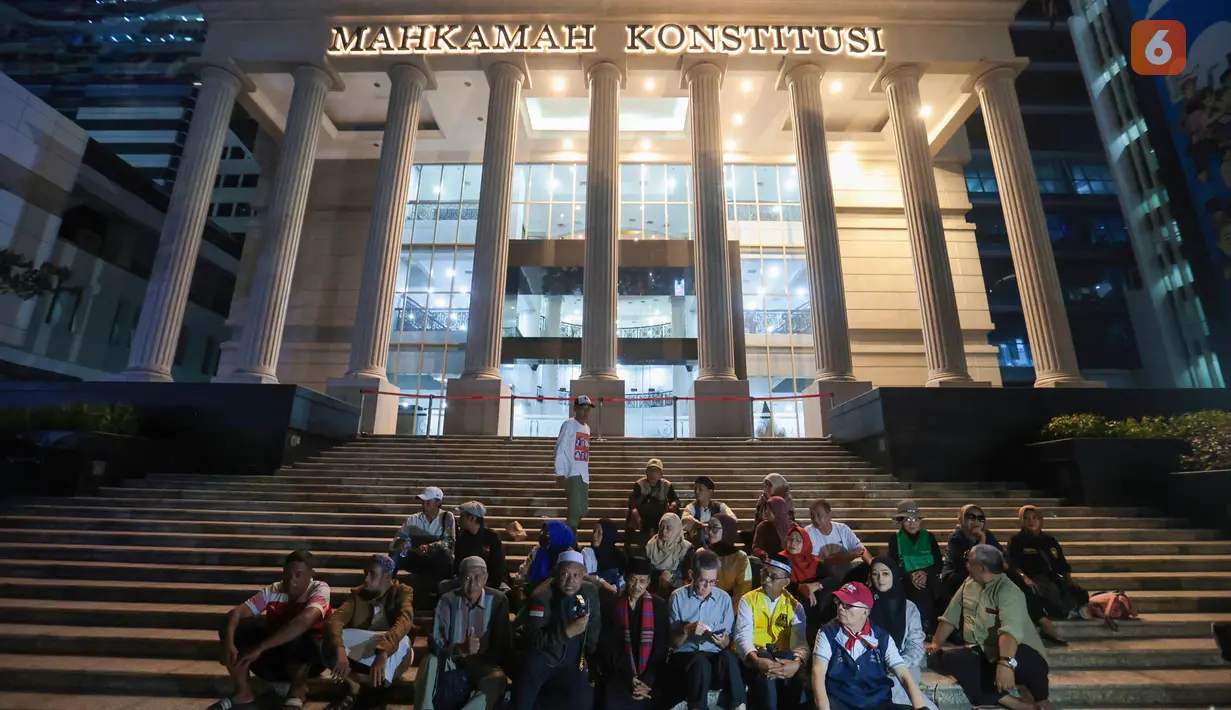 Para pendukung pemohon duduk di depan Gedung Mahkamah Konstitusi (MK) dengan ekspresi kecewa usai pembacaan putusan perkara Perselisihan Hasil Pemilihan Umum (PHPU) di Jakarta Pusat, Selasa (6/10/2026). (KLY/Budy Santoso)