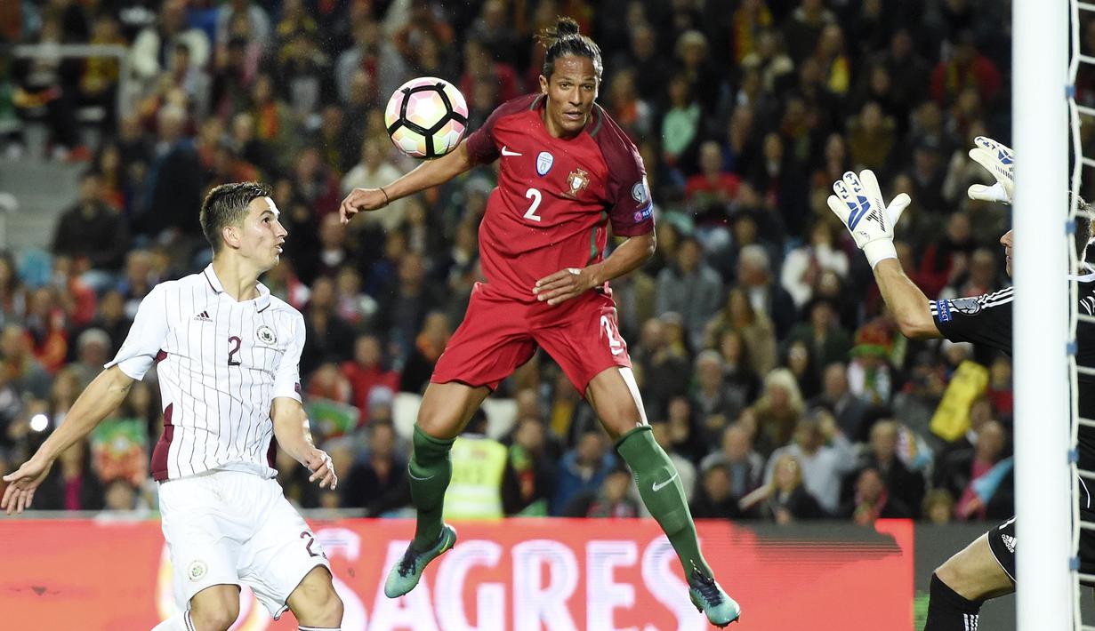 Pemain Portugal, Bruno Alves (tangah) menyundul bola ke gawang Latvia pada laga Kualifikasi Piala Dunia 2018 di Algarve stadium, Faro (13/11/2016). Portugal menang 4-1. (AFP/Francisco Leong)