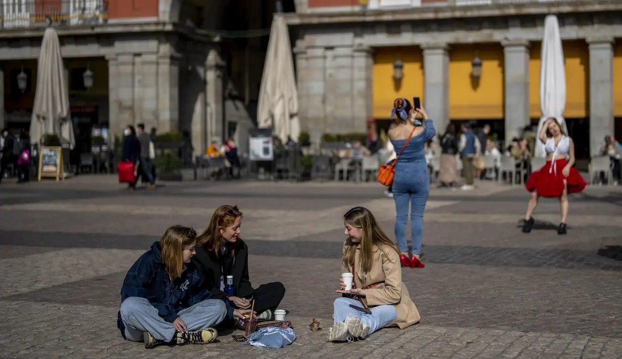 Sekelompok perempuan tanpa masker wajah berkumpul di alun-alun Plaza Mayor di pusat kota Madrid, Kamis (10//2/2022). Warga Spanyol untuk pertama kalinya dalam hampir dua bulan diperbolehkan tidak menggunakan masker di luar ruangan setelah peraturan terkait hal itu dicabut. (AP Photo/Manu Fernandez)