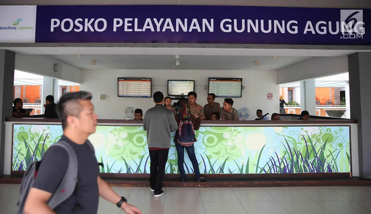 Calon penumpang bertanya di posko pelayanan Gunung Agung di Bandara Internasional I Gusti Ngurah Rai, Bali, Kamis (30/11). Bandara tersebut kembali beroperasi terhitung pukul 15.00 WITA, Rabu (29/11). (Liputan6.com/Immanuel Antonius)