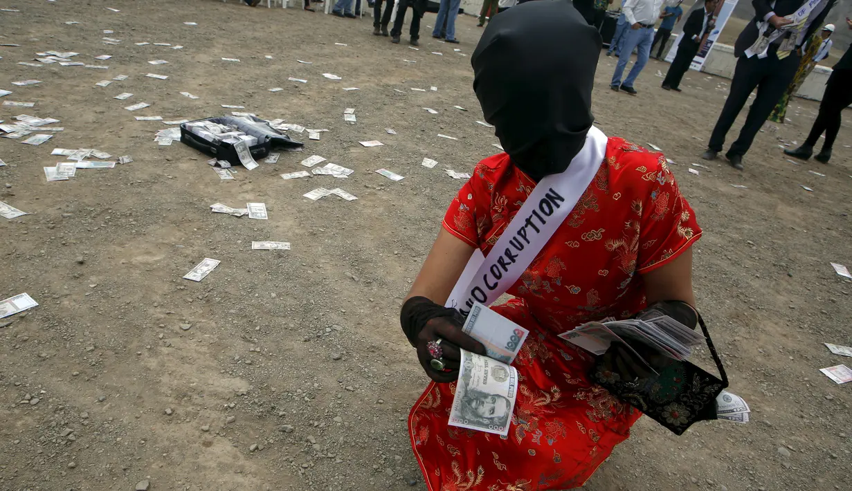 Wanita mengambil uang yang berjatuhan selama melakukan tetrikal dalam partisipasi mengungkap korupsi di Lima,Peru, (12/11/2015).  Mereka ingin menciptakan kepada masyarakat akan kesadaran tentang korupsi. (REUTERS/Mariana Bazo)
