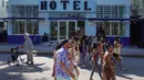 Orang-orang berjalan di sepanjang Ocean Drive di Miami Beach, Florida, Selasa (16/3/2021). Mahasiswa telah tiba di daerah Florida Selatan untuk liburan musim semi. Para pejabat kota prihatin dengan kerumunan liburan musim semi saat pandemi COVID-19 terus berlanjut. (Joe Raedle/Getty Images/AFP)