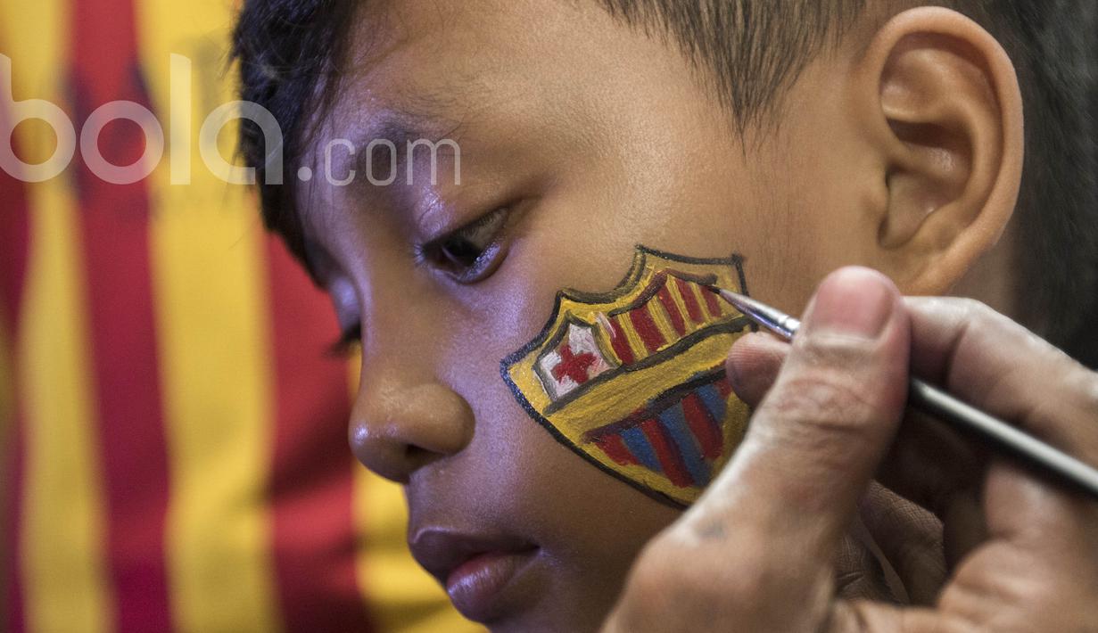 Seorang fans Barcelona mewarnai wajahnya sebelum nonton bareng bersama Bola.com dan Head & Shoulders di Senayan, Jakarta, Minggu (24/4/2017). (Bola.com/Vitalis Yogi Trisna)