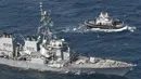 Sebuah kapal tunda menghampiri kapal perusak USS Fitzgerald yang rusak usai bertabrakan dengan kapal dagang di prefektur Shizuoka, Jepang (17/6). Ketujuh pelaut yang sebelumnya dilaporkan hilang ditemukan tewas. (Iori Sagisawa/Kyodo News via AP)