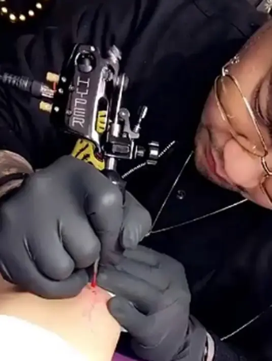 Dengan posisi tidur tengkurap, Kylie Jenner membiarkan seniman tato mengukir tinta di tubuhnya. Kylie pun merasa tak sakit ketika dirinya harus berhadapan dengan jarum tato. (Instagram/Bintang.com)