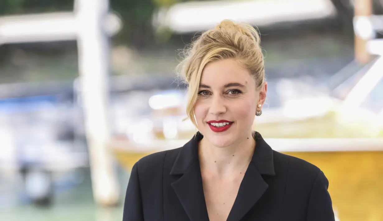 Greta Gerwig berpose untuk fotografer saat tiba untuk sesi pemotretan film 'White Noise' selama Festival Film Venesia edisi ke-79 di Venesia, Italia, Rabu (31/8/2022). Greta Gerwig tampil cantik mengenakan setelan jas berwarna hitam. (Photo by Vianney Le Caer/Invision/AP)