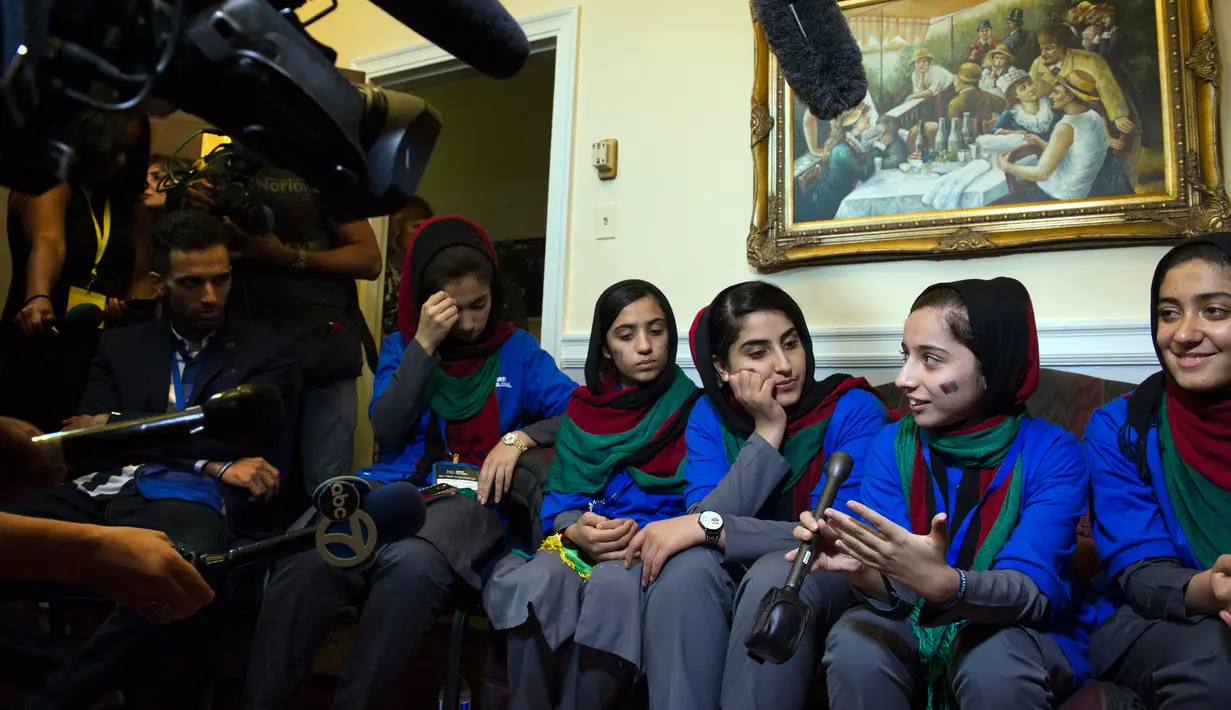 Para Robotika dari Afghanistan melakukan wawancara dengan beberapa wartawan setelah upacara pembukaan The First Global Challenge di Washington, Amerika, Minggu (16/7). Kompetisi ini berskala internasional dan berlangsung selama 3 hari. (AP/Cliff Owen)