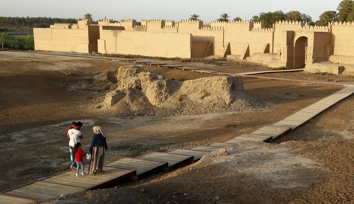 Orang-orang mengunjungi situs arkeologi Babilonia, Irak, Minggu (21/3/2021). Komite Warisan Dunia UNESCO telah menetapkan kota kuno Babilonia di Mesopotamia sebagai Situs Warisan Dunia. (AP Photo/Hadi Mizban)