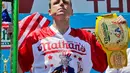 Joey Chestnut mengangkat trofi usai memenangkan Lomba Makan Hot Dog Nathans di New York, AS (4/7). Joey Chestnut menang untuk kesepuluh kalinya sekaligus mencetak rekor baru. (AP Photo/Bebeto Matthews)