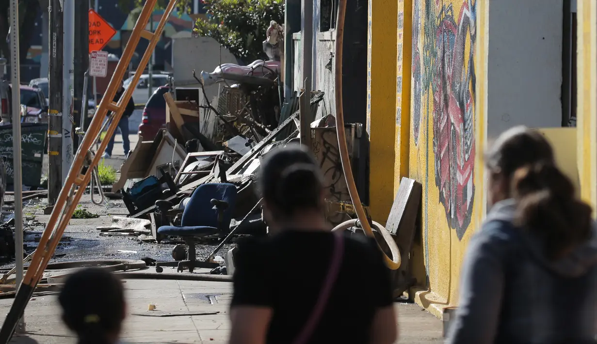 Sejumlah warga mendatangi lokasi kebakaran sebuah kelab malam di Oakland, California, Sabtu (3/12). Menurut penjelasan Kepala Pemadam Kebakaran setempat, gedung itu tak memiliki alat pemadam api yang memadai. (Elijah Nouvelage/GETTY IMAGES/AFP)