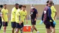 Pelatih Barcelona, Quique Setien, mengamati anak asuhnya saat menggelar latihan di Joan Gamper, Barcelona, Senin (25/5/2020). Latihan tersebut untuk persiapan jelang kembali bergulirnya La Liga Spanyol. (AFP/Miguel Rui)