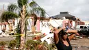 Ekspresi seorang wanita yang berdiri di dekat rumahnya yang rusak akibat hantaman Tornado di New Orleans, AS (7/2). (Sean Gardner/Getty Images/AFP)