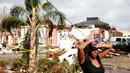 Ekspresi seorang wanita yang berdiri di dekat rumahnya yang rusak akibat hantaman Tornado di New Orleans, AS (7/2). (Sean Gardner/Getty Images/AFP)