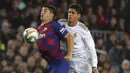 Penyerang Barcelona, Luis Suarez mengontrol bola dari kawalan bek Real Madrid, Raphael Varane pada pertandingan lanjutan La Liga Spanyol di stadion Camp Nou (18/12/2019). Barcelona bermain imbang 0-0 atas Real Madrid. (AP Photo/Emilio Morenatti)