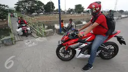 Pengendara motor menunggu giliran melintas untuk menyeberangi KBB di kawasan Tanah Abang, Jakarta, Jumat (30/12). Tidak tersedianya fasilitas penyeberangan lain membuat warga serta pengendara harus berbagi jalan. (Liputan6.com/Immanuel Antonius)