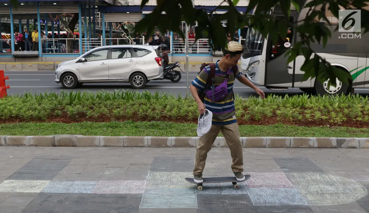 Pejalan kaki bermain skate board di trotoar sekitar Halte Gelora Bung Karno, Jakarta, Jumat (17/5/2019). Koalisi Pejalan Kaki melakukan eksperimen permainan untuk mengedukasi kegiatan mengembalikan fungsi trotoar lebih dari sekedar ruang berjalan kaki. (Liputan6.com/Helmi Fithriansyah)