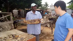 Seorang pedagang memperlihatkan kepala binatang kepada turis yang sedang mengunjungi pasar jimat Akodessewa di Togo, Afrika, 5 Agustus 2015. Pasar ini menjual berbagai benda-benda klenik dan juga peralatan sihir. (AFP PHOTO/EMILE KOUTON) 