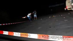 Juru kamera mengambil gambar di lokasi seorang remaja menyerang penumpang kereta di dekat kota Wurzburg, Jerman, Senin (18/7). Insiden ini mengakibatkan 10 orang terluka dan tiga di antaranya dalam kondisi cukup serius. (REUTERS/Kai Pfaffenbach)