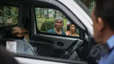 Seorang warga berkerumun melihat penemuan mayat dalam mobil di kawasan Taman Wiladatika, Jakarta Timur, Minggu (3/5/2015). Mayat pria yang diketahui bernama Sunoto (41) tersebut ditemukan oleh seorang penyapu jalanan. (Liputan6.com/Faizal Fanani)