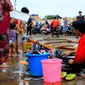 Warga mencuci usai banjir melanda Kampung Melayu, Jakarta, Jumat (3/1/2020). Banjir yang melanda Kampung Melayu menyisakan sisa sampah dan lumpur. (merdeka.com/Magang/Muhammad Fayyadh)