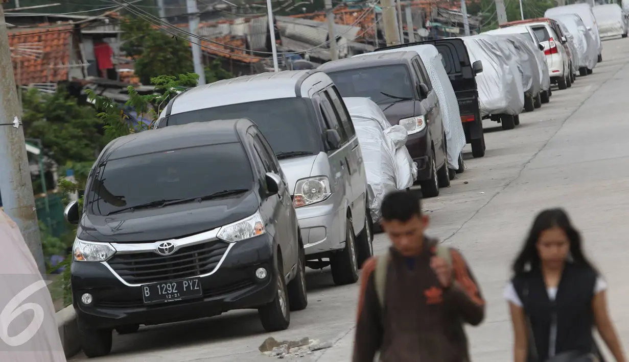 Pejalan kaki melintas di jalur inspeksi Kanal Banjir Barat, Jakarta, Senin (6/3). Keterbatasan lahan menyebabkan sejumlah kendaraan parkir di tempat tersebut, meskipun telah terpampang larangan parkir. (Liputan6.com/Immanuel Antonius)