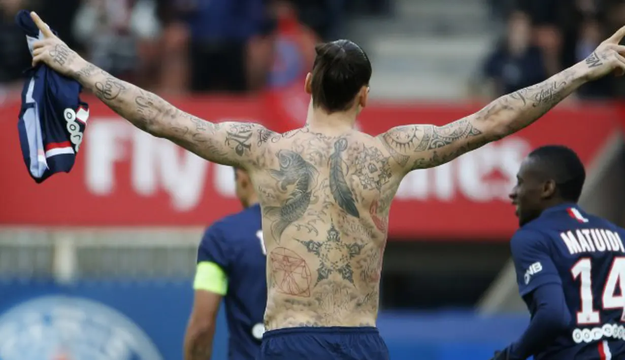 Ibrahimovic membuka papan skor di menit kedua di Parc des Princes, dan langsung melepas jersey yang ia kenakan untuk memamerkan tato yang memenuhi tubuhnya sebagai selebrasi pada 14 Februari 2015. (AFP Photo/Kenzo Tribouillard)